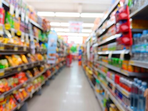 Blur image of supermarket shelves grocery store aisle as defocused abstract background with bokeh lights.