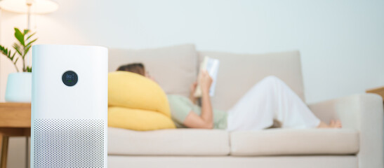 Air Purifier with woman read and relax on sofa. Purification system for filter and cleaning dust...