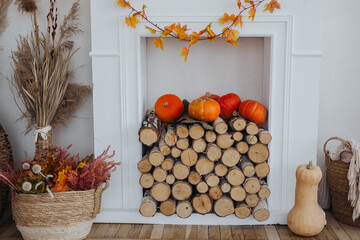 Cozy autumn decor featuring pumpkins and wood logs arranged in a charming fireplace setting
