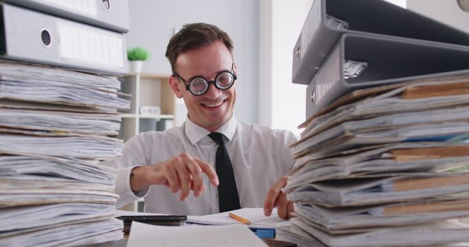 Funny squint tired manager wearing glasses, crazy overload with paperwork, feeling fatigue and burnout at workplace, suffering from bad eye sight, office employee among huge paper piles of documents