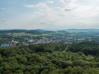 Obraz premium Panoramic view from sandstone rock lookout Jehla near Ceska Kamenice town. Summer landscape in Lusatian Mountains with green hills and mixed forest.