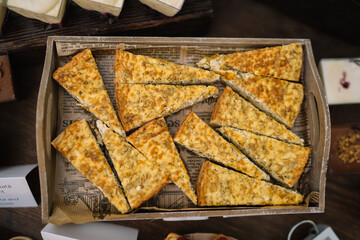 Stacked cheese slices with toppings in a rectangular tray