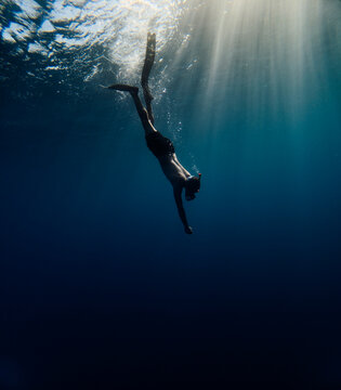 Man dives towards the bottom of the sea