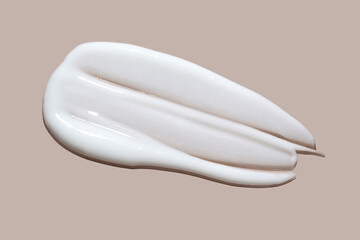 White cosmetic cream lotion swatch smear smudge on brown color background