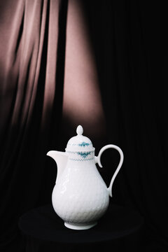 A single blue-pattern teapot in front of dark background