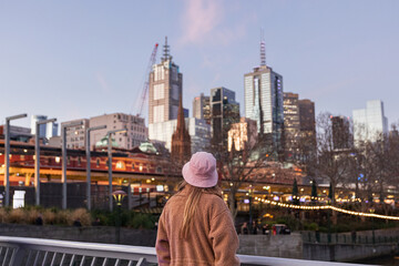 Person observing Melbourne city skyline during twilight hour