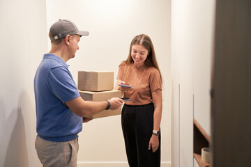 Delivery Person Handing Over Packages to Recipient Indoors