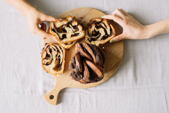 Variations of chocolate swirl bread on wooden board.