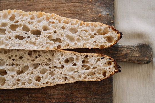 Artisan bread cut lengthwise displaying airy crumb