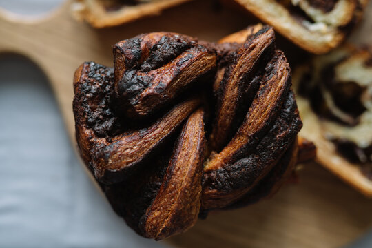 Freshly baked chocolate swirl bread on wooden board.