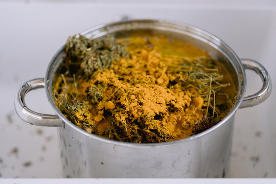 Large pot with yellowish herbal mixture soaking inside.