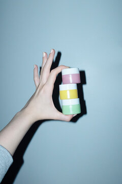 Hand and pastel coloured cosmetic beauty product lotion balms 