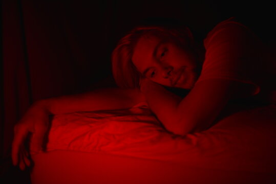 A young man in his bedroom at night