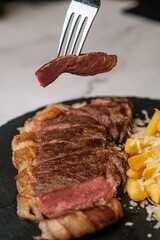 Delicious Steak Bite on Fork with Garnish in Background