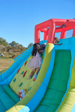 Little girl playing on inflatable bouncy castle