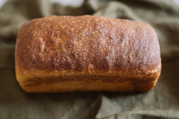 Golden-brown artisanal bread loaf on green fabric