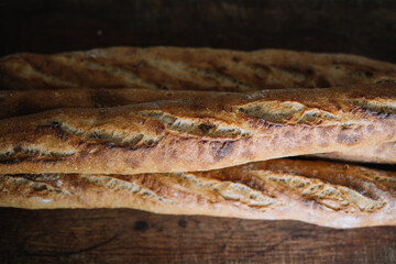 Top-down view of golden crusted baguettes on rustic board.
