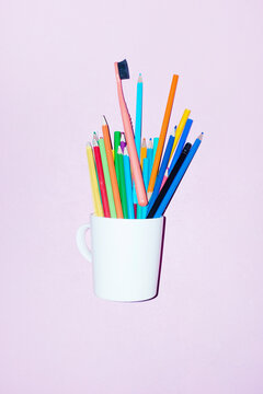 Coffee cup and color pencils and tooth brushes on office business desk