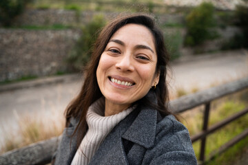 A happy hispanic business woman taking a selfie after work