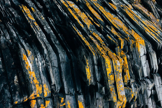 Close-up of rugged rock surface with unique yellow and black patterns - Powered by Adobe
