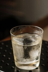 Refreshing Cocktail with Large Ice on a Table and Lamp