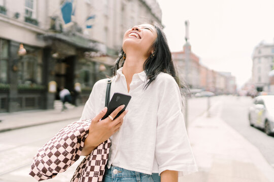 Woman Checking Phone in City