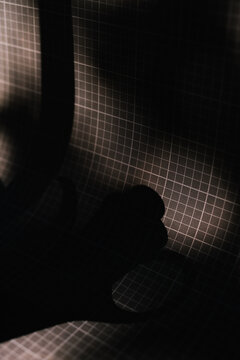 Dark shadow with grid texture creating abstract shapes.