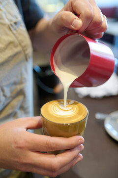 Pouring Milk Foam Into Coffee for Latte Art at Cafe