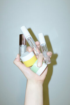 Hand and pastel coloured cosmetic beauty product lotion balms 