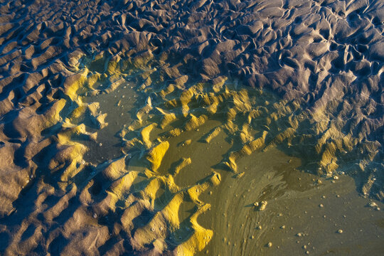 Tide pool at dusk, foam on water surface