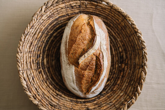 Artisan bread loaf resting in a rustic woven container