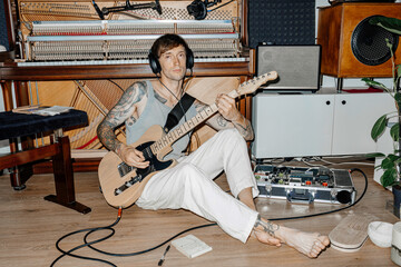 A musician with a guitar writes music