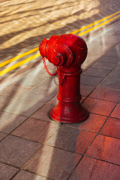 Red Fire Hydrant on Sunlit Urban Sidewalk