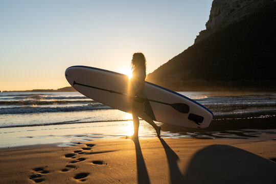 Paddleboarder walking towards the sea.