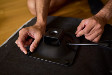 A Young Man Assembling a Stylish Modern Chair in a Comfortable Minimalist Interior Space