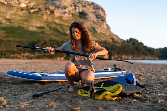 Woman preparing oar for paddleboarding.