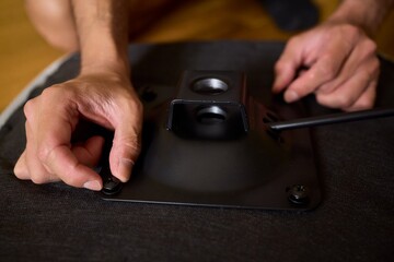 A Young Man Assembling a Stylish Modern Chair in a Comfortable Minimalist Interior Space