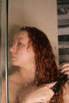 Woman showering and untangling her hair 
