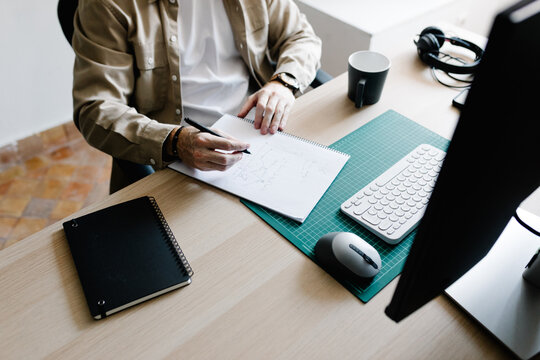 Anonymous creative making notes on a blank sheet