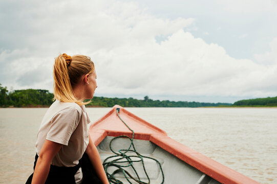 Blonde woman exploring rainforest in a boat