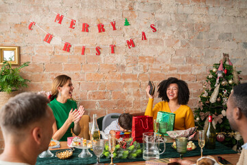 Woman happy about her received present at Christmas dinner indoors