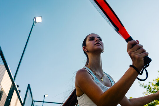 Fitness college girl intensely playing a game of padel on a sunny day