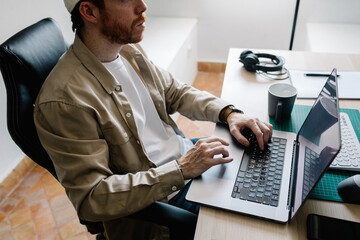 Man types on his laptop during a remote work session from home