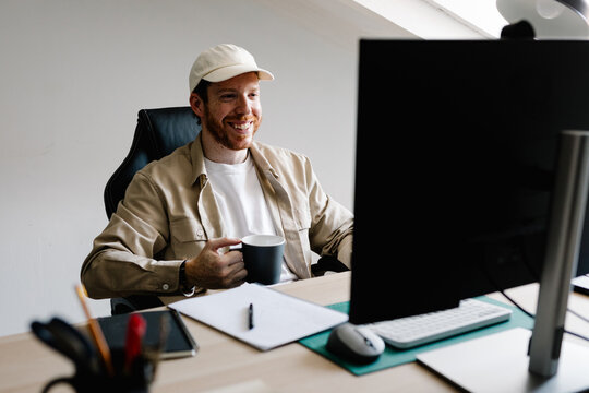 A publicist happily attends clients on a virtual call with a computer