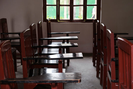 Closeup of old-fashioned desks and chairs in an empty old classroom