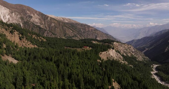 Aerial Establishing Shot Above Fairy Meadows Camp and Cabins, Dense Pine Forest and Rugged Mountain Cliffs