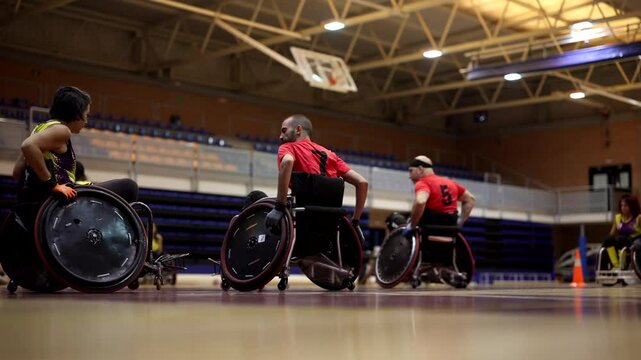 Wheelchair rugby paralympic athletes strategizing with their team during a timeout in a brightly lit gymnasium
