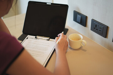 Focused young asian woman sitting and reading electronic document, checking the contract to send to her business partner. Concentrated smart ambitious business woman preparing research, freelance work