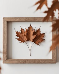 Obraz premium Artistic arrangement of autumn leaves in wooden frame.