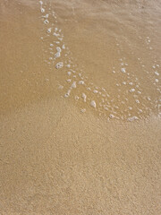 
It is a sandy beach with waves rolling in.